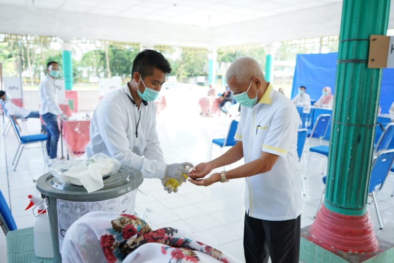 Bupati Asahan H. Surya, BSc didampingi istri Ny. Hj. Titiek Sugiharti Surya menggunakan hak pilihnya di TPS 7 Kelurahan Mekar Baru Kecamatan Kota Kisaran Barat, Rabu (09/12/2020).    